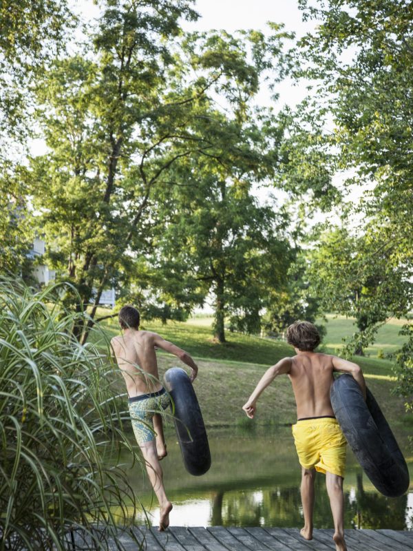 One Straw Farm,USA,Two boys, leaping from the jetty into the water holding swim floats. Two boys, leaping from the jetty into the water holding swim floats.